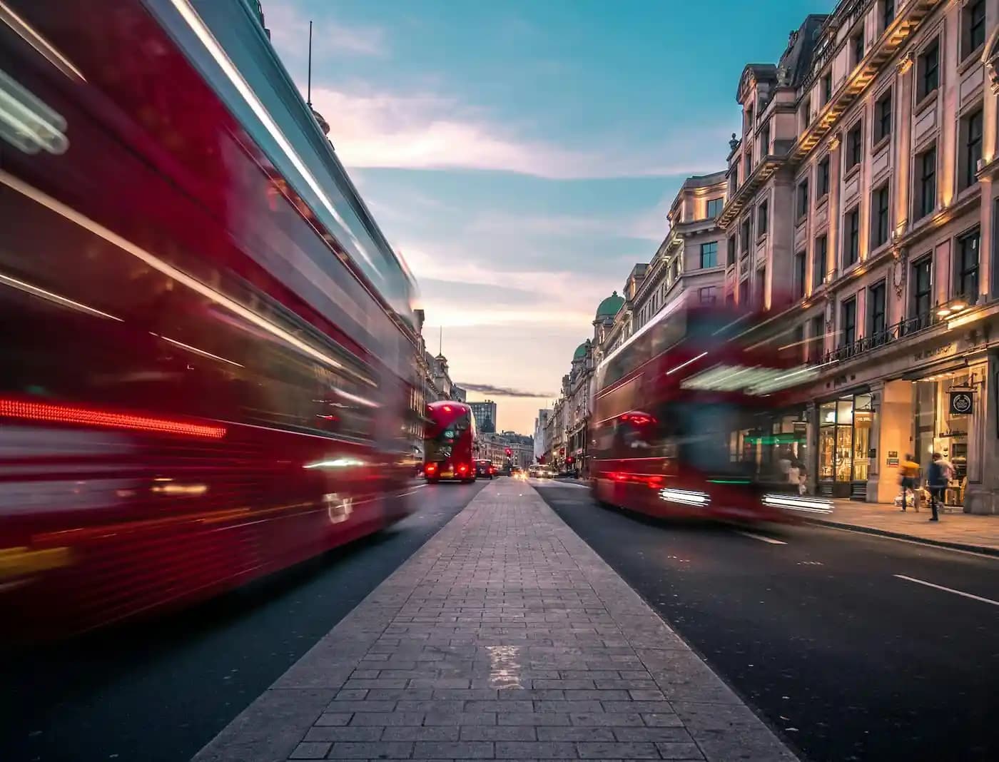 Top-down view of two padel rackets and five tennis balls scattered on a blue padel court.